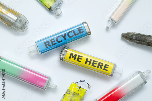 Recycle Me Here concept printed inside discarded electronic cigarette vapes. Vibrant colours shot over a white paper background.