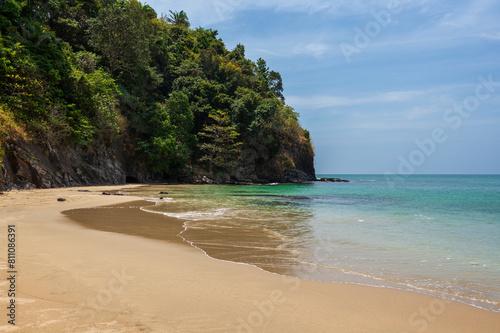 Idyllic and small Nui Bay Beach in Koh Lanta, Thailand, on a sunny day. Beautiful tropical landscape with quiet beach, blue sky and turquoise water.