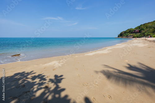 Idyllic Nui Beach in Koh Lanta, Thailand, on a sunny day. Beautiful tropical landscape with quiet beach, blue sky and turquoise water.