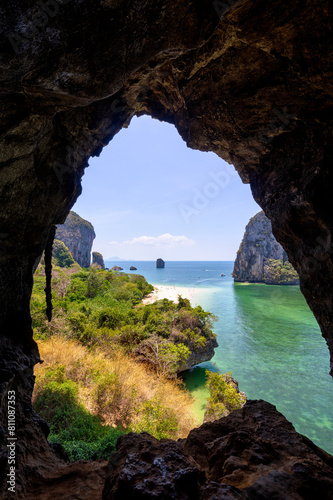 Scenic landscape of the Phranang (Phra Nang) Cave Beach and steep limestone karst cliffs on a sunny day in Railay, Krabi, Thailand, viewed from above from a cave.