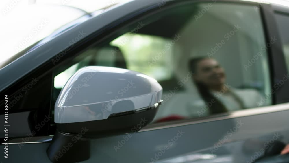 A successful business woman buys an electric car at a car dealership. A young woman enjoys an expensive purchase. Concept of modern automobile technologies, test drive, and insurance. A successful business woman buys an electric car at a car dealership. A young woman enjoys an expensive purchase. Concept of modern automobile technologies, test drive, and insurance.