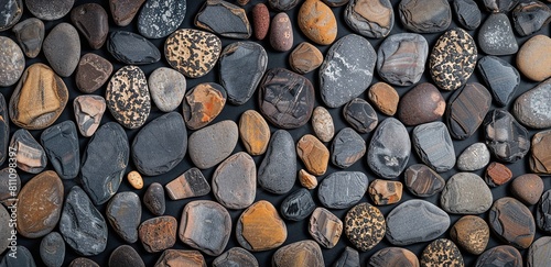 A background of smooth  round pebbles in various colors and sizes arranged neatly together