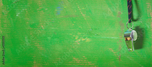 Whistle of soccer referee or coach on green background.Great international soccer event in europe this year. Panoramic,negative space technique Free copy space.