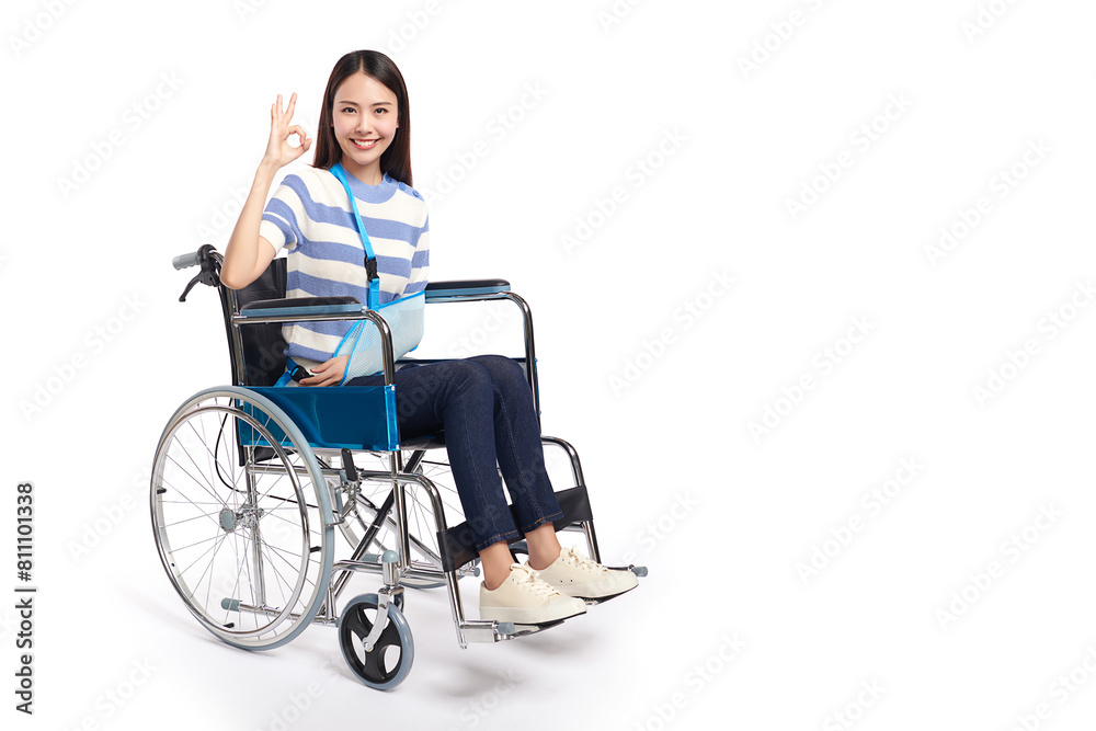 Beautiful young asian women with happy smiling sitting in a wheelchair on white background and she shows ok sign, healthcare concept, accident, insurance, life insurance, wellness, hospital. Beautiful young asian women with happy smiling sitting in a wheelchair on white background and she shows ok sign, healthcare concept, accident, insurance, life insurance, wellness, hospital.