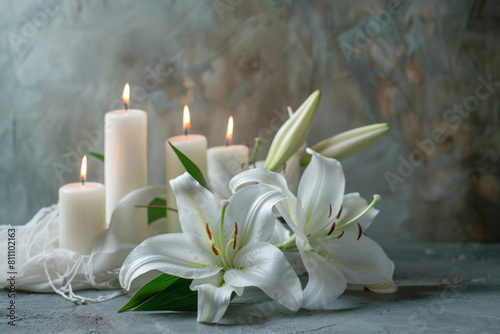 Peaceful condolence background with white lilies and lit candles on a textured grey surface, symbolizing sympathy and remembrance