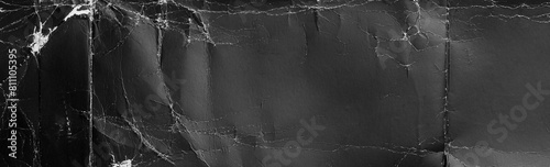 Crumpled black paper with wrinkles and rubbed corners. Old wrapping dusty cardboard