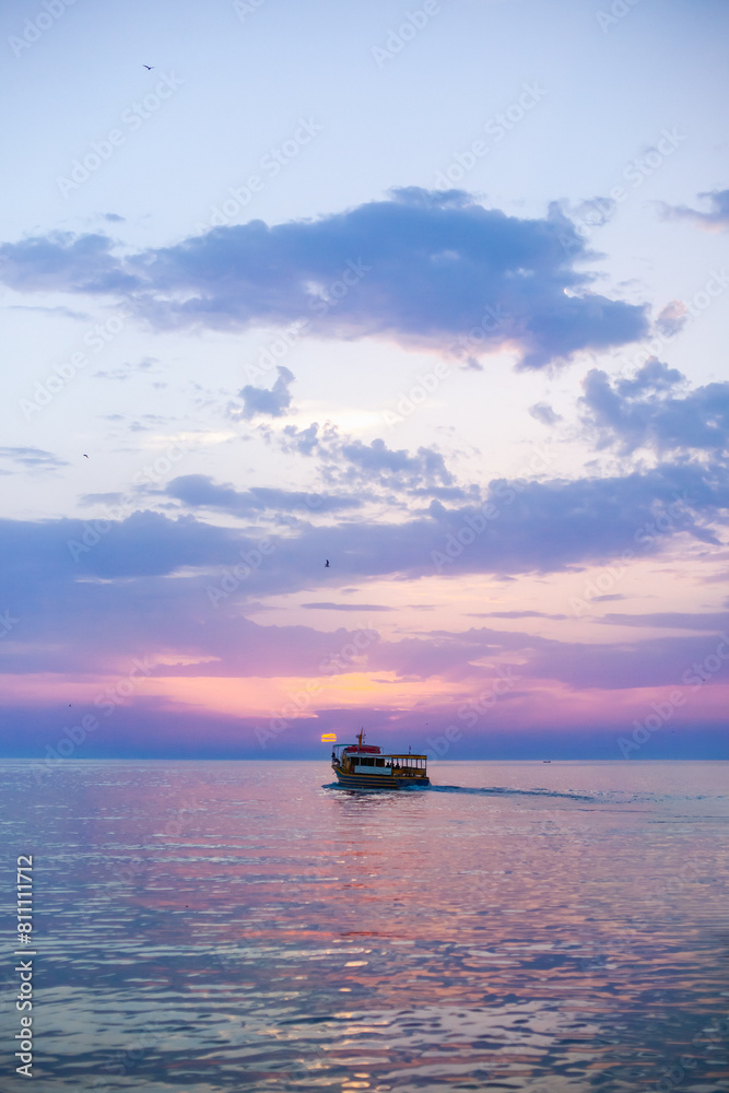 Naklejka premium Beautiful sunset over calm sea, with vivid colors and clouds in the sky. Serenity and nature concept
