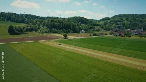 Aerial view of tractor harvester working in green agriculture field in spring photo
