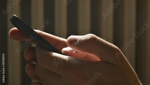 Typing mobile phone text message with thumbs, closeup of male hands