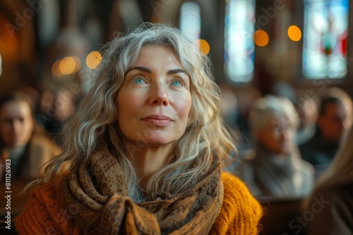 A mature woman lost in thought among other congregants in a church photo