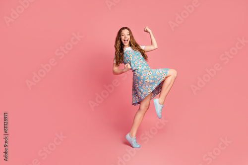 Full size photo of cute young girl raise fists wear dress isolated on pink color background photo