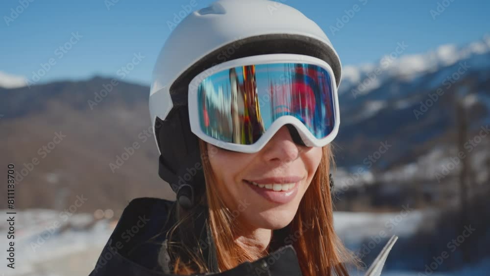 Close-up portrait of smiling woman snowboarder skyer in ski helmet and glasses in mountains, side view. Girl wearing in ski clothes in winter resort. Enjoy healthy active rest, snowboarding lifestyle. Close-up portrait of smiling woman snowboarder skyer in ski helmet and glasses in mountains, side view. Girl wearing in ski clothes in winter resort. Enjoy healthy active rest, snowboarding lifestyle.