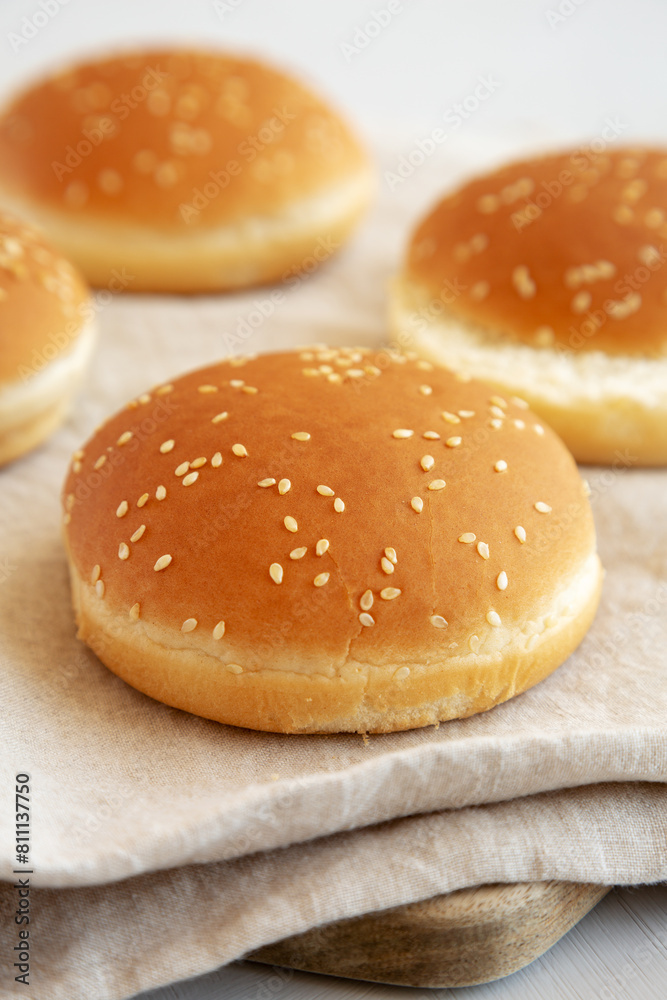 Classic Sesame Seed hamburger Buns on a Wooden Board, side view.