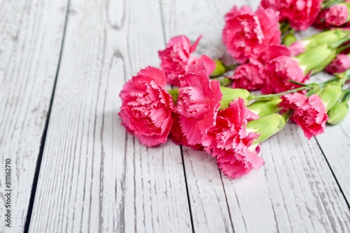 Red and pink carnations bouquet on wooden background. Mother's Day background. Love mom. Copy space. © ginahsu