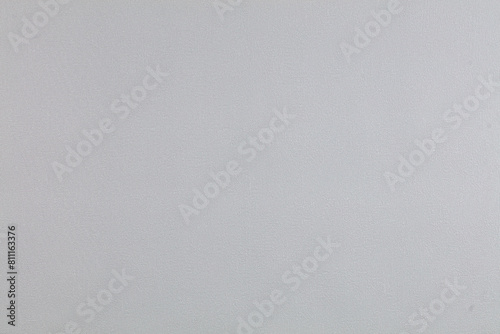 Background of gray evenly textured paper wallpaper. Gray plastered wall.
