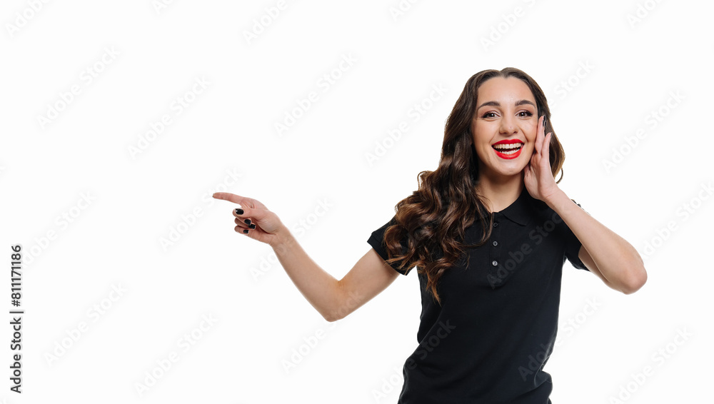 A woman in a black shirt points to the camera with a big smile on her face. She is wearing red lipstick and has her hair in a ponytail. A woman in a black shirt points to the camera with a big smile on her face. She is wearing red lipstick and has her hair in a ponytail.