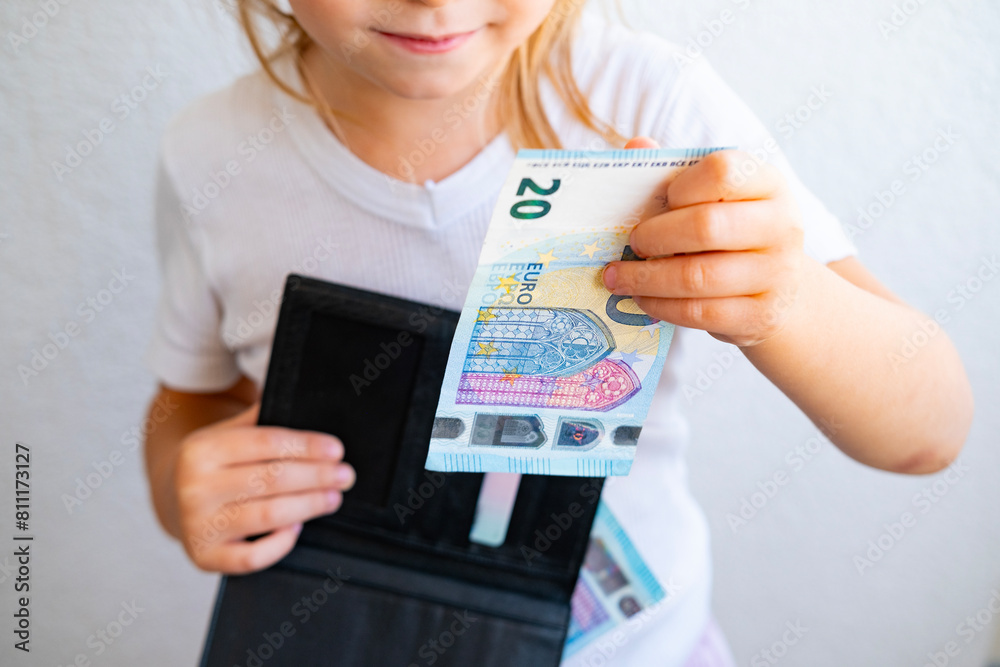 child holds black wallet in hand, kid, girl secretly takes money out of parents' wallet, pulls out euro banknotes, concept of pocket money, Personal Boundaries and Trust, Teaching Financial Literacy child holds black wallet in hand, kid, girl secretly takes money out of parents' wallet, pulls out euro banknotes, concept of pocket money, Personal Boundaries and Trust, Teaching Financial Literacy