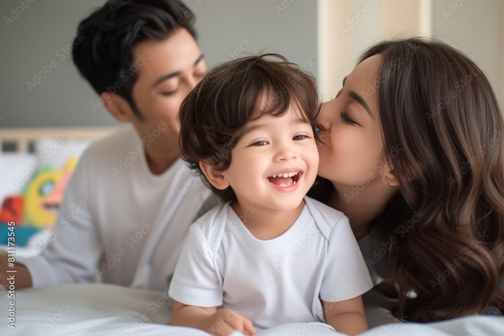 happy child with parents playing in the bed at home happy child with parents playing in the bed at home