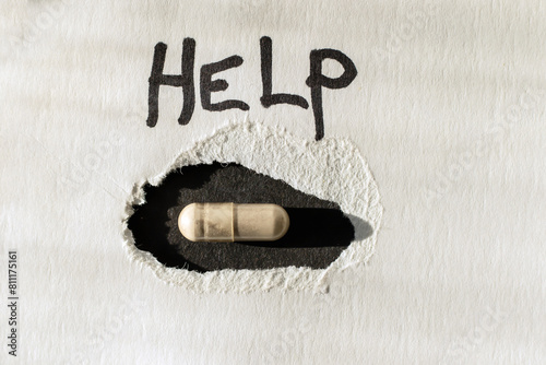 White background with a black hole in which lies a capsule with medicine. Close-up view from above.