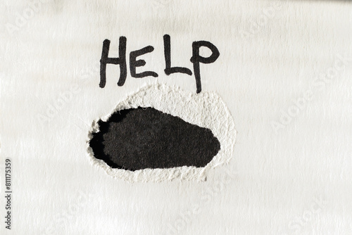 White cardboard with a large black hole. Close-up view from above.