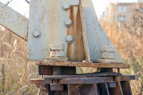 Old metal triangular support with rusty bolts.