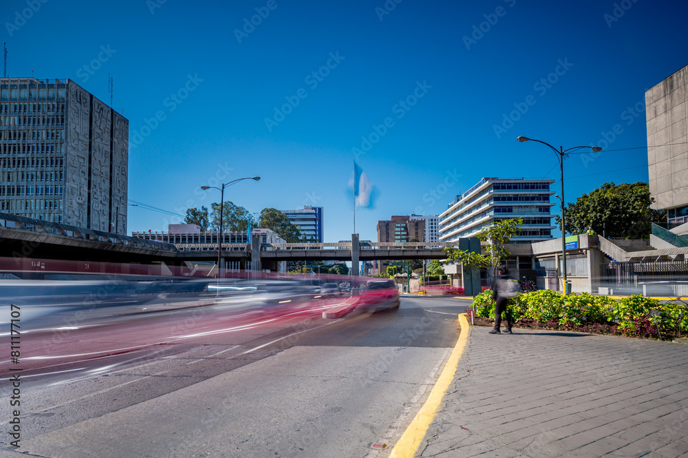 Image of an avenue with moving vehicles in Guatemala City. View of municipal government buildings and the financial system. Image at low speed.