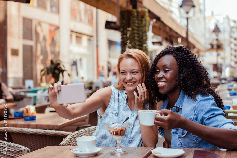 Two young women taking selfie in street cafe Two young women taking selfie in street cafe