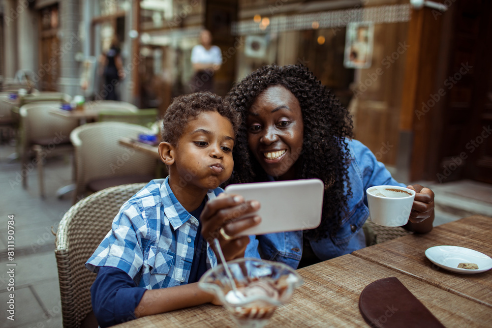 Black mother and son taking a selfie at a cafe Black mother and son taking a selfie at a cafe