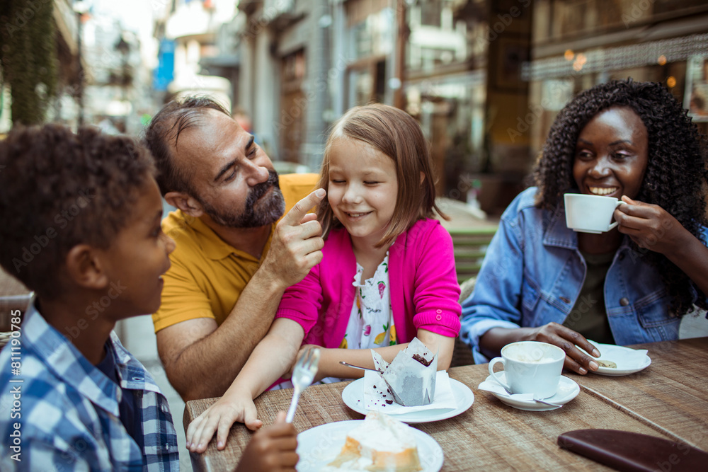 Happy multiethnic family enjoying time at a cafe together Happy multiethnic family enjoying time at a cafe together