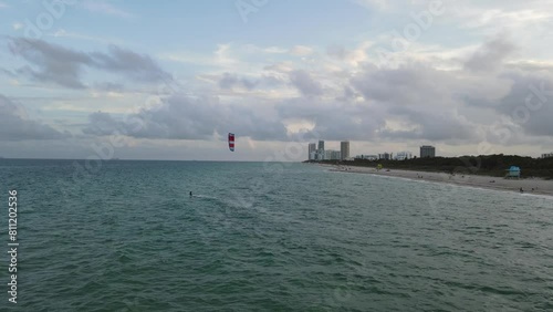 Aerial footage of a surfer kitesurfing off Miami beach at sunset in Miami, Florida, United States