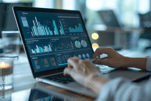 Business woman using a tablet computer and laptop with financial data, graphs or charts for business strategy planning in an office background. A business man working on a digital table © Ikhou