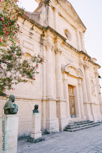 Blooming oleander and busts on pedestals near the Church of the Nativity of the Virgin. Prcanj, Montenegro photo