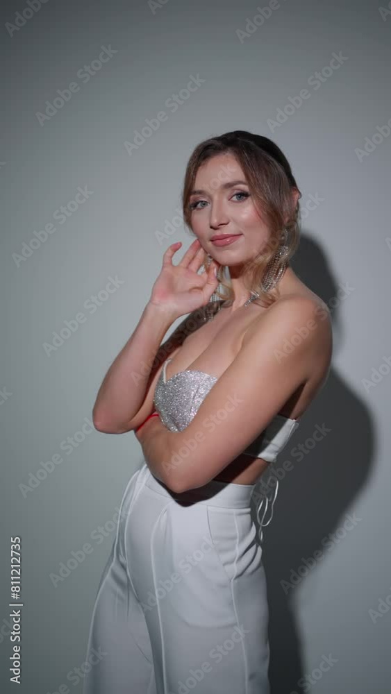 Joyful woman in shiny top is posing and smiling at camera. Joyful woman in shiny top is posing and smiling at camera.