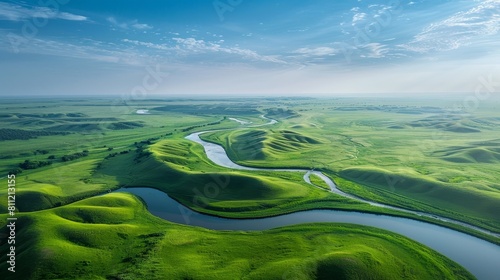 Expansive aerial landscape of rolling green hills,winding rivers,and wispy cloud-filled blue skies in the American heartland photo