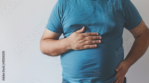 Casual-dressed middle-aged man with indigestion or discomfort. Holding stomach, health issue concept. Suitable for medical content. Neutral background. AI photo