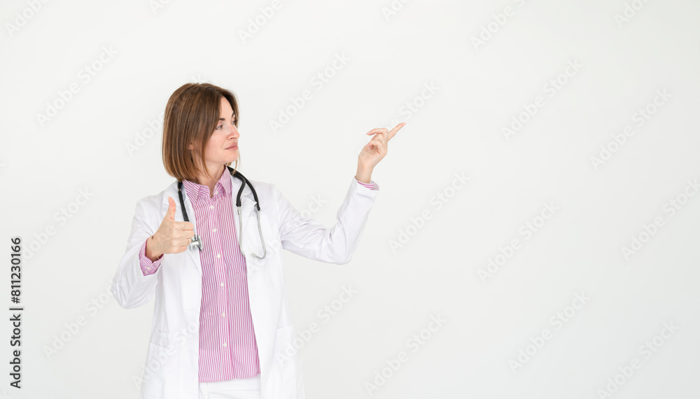 Female doctor standing and pointing on free space isolated on white background Female doctor standing and pointing on free space isolated on white background