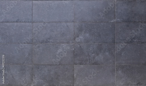 Dark gray horizontal stone tiles for ventilated facade cladding. Background and texture photo