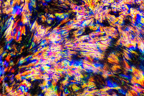 Extreme macro photograph of Meloxicam crystals forming vibrant abstract modern art patterns, when illuminated with polarized light, under a microscope objective with 50x magnification photo