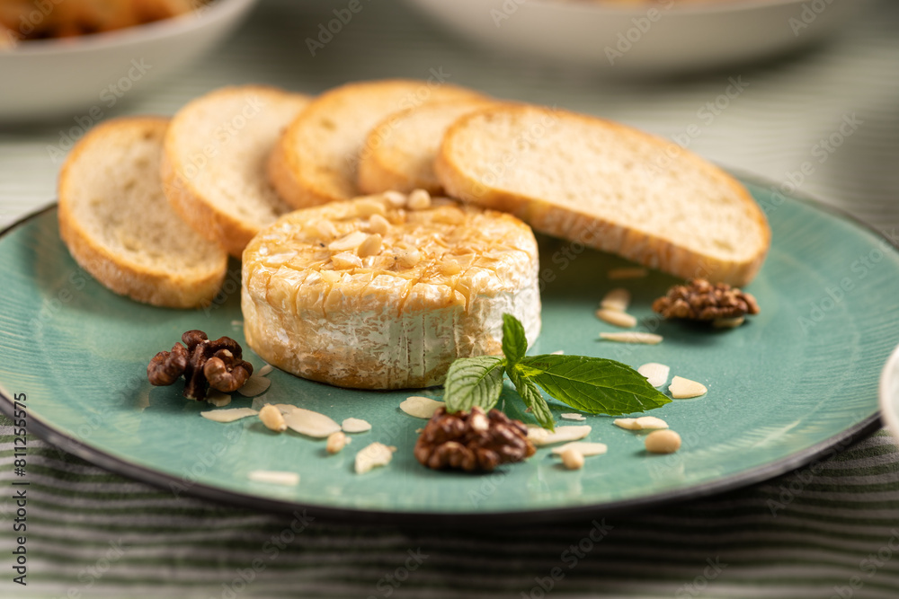 Baked camembert cheese with baguette bread grilled toasts and leaves. Baked camembert cheese with baguette bread grilled toasts and leaves.