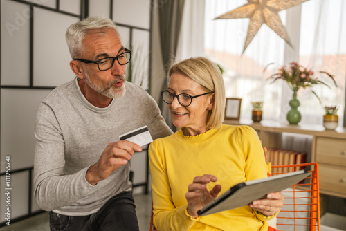 Mature caucasian husband and wife shopping online sit at home