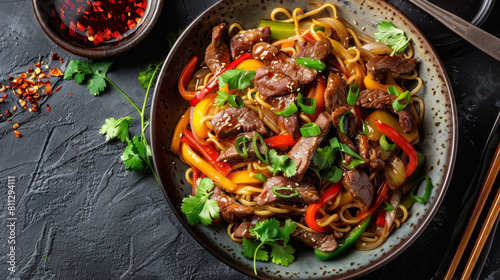 Authentic mongolian beef stir-fry, served with colorful bell peppers, onions, and noodles, garnished with sesame seeds and fresh coriander