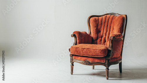 A retro-style wooden chair with inviting orange cushions, placed against a plain white backdrop. 