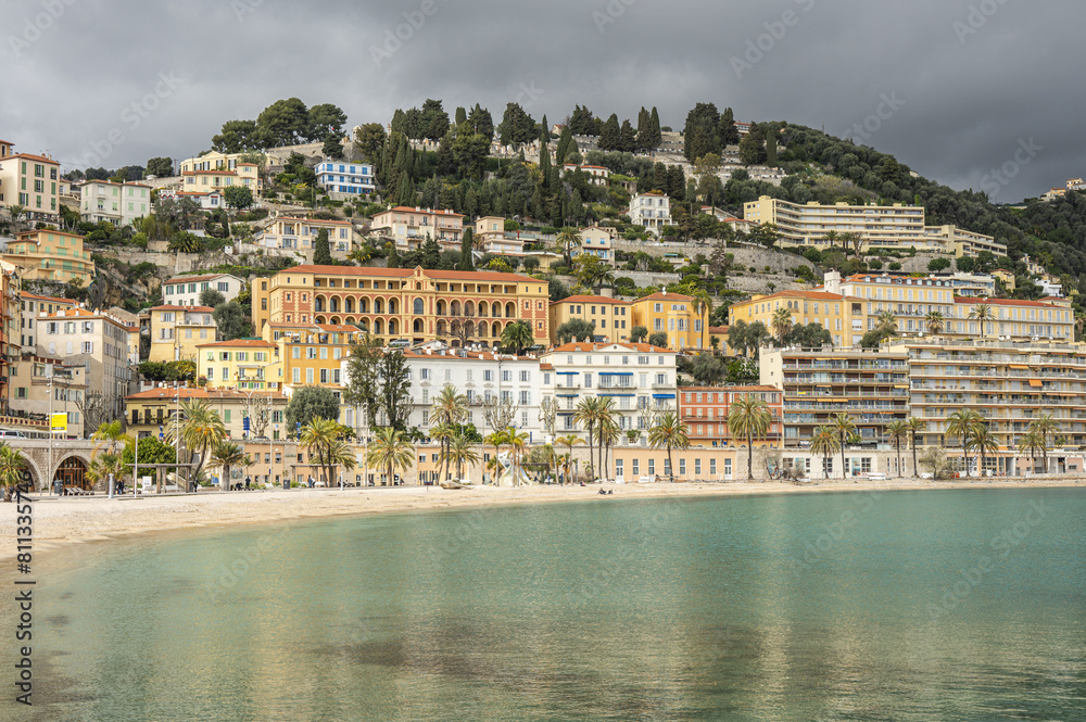menton, France - 04-01-2024: The beautiful beach of Menton with turquoise water and beautiful colorful houses in the background menton, France - 04-01-2024: The beautiful beach of Menton with turquoise water and beautiful colorful houses in the background