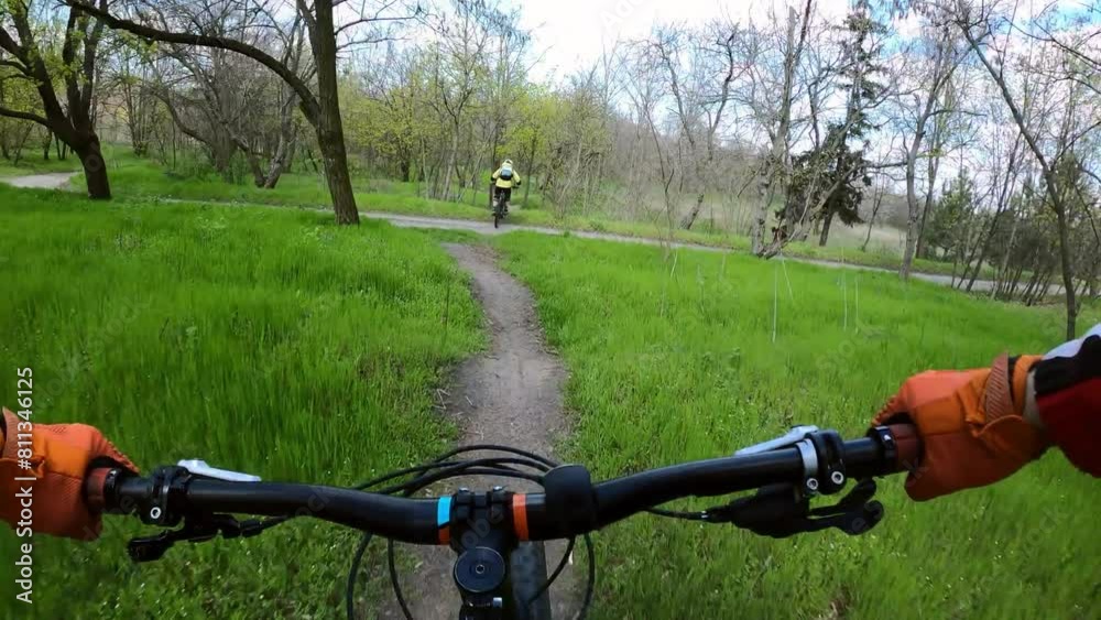 Two cyclists are riding on a difficult forest trail on mountain bikes. MTB. FPV.