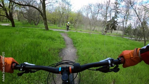 Two cyclists are riding on a difficult forest trail on mountain bikes. MTB. FPV.