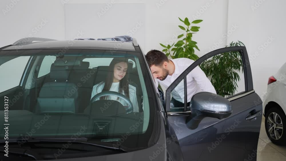 Seller showing to a female customer car options before buying new car auto