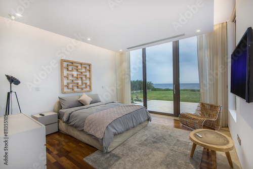 Bedroom With Large Bed and Ocean View.A spacious bedroom positioned to overlook a vast expanse of the ocean through expansive windows.