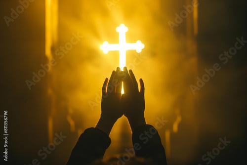 backlit image of a believer hands to heaven worshiping the cross	