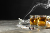 Alcohol and drug addiction. Whiskey in glasses and syringes on grey background, space for text