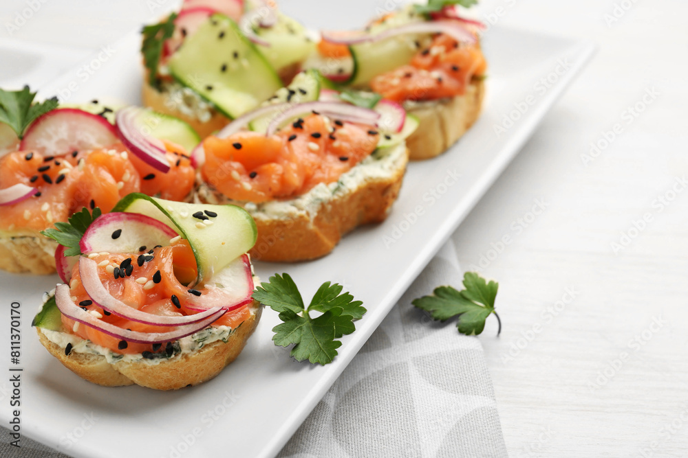 Tasty canapes with salmon served on white wooden table, closeup. Space for text Tasty canapes with salmon served on white wooden table, closeup. Space for text